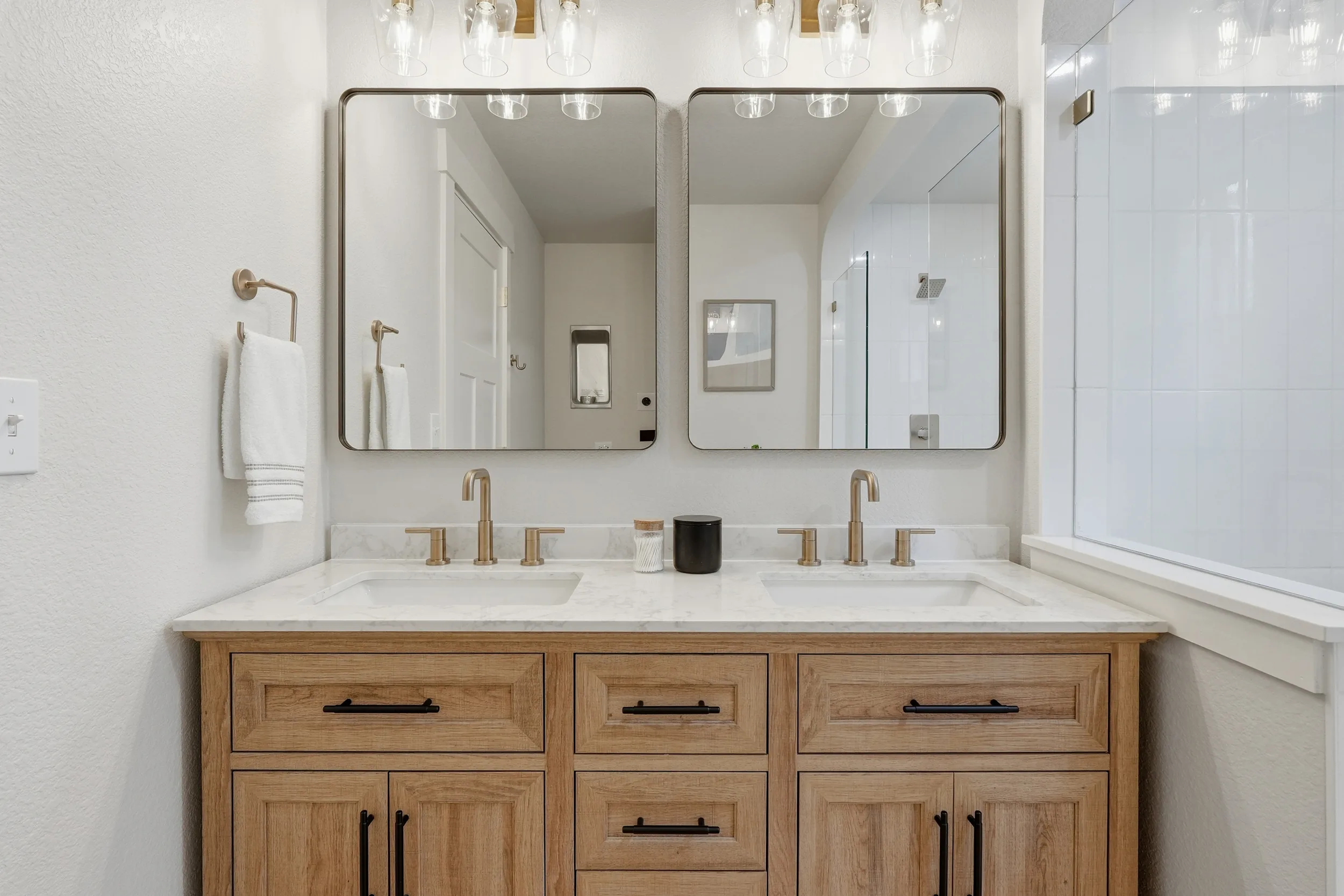 Double vanity with brass faucets and two mirrors