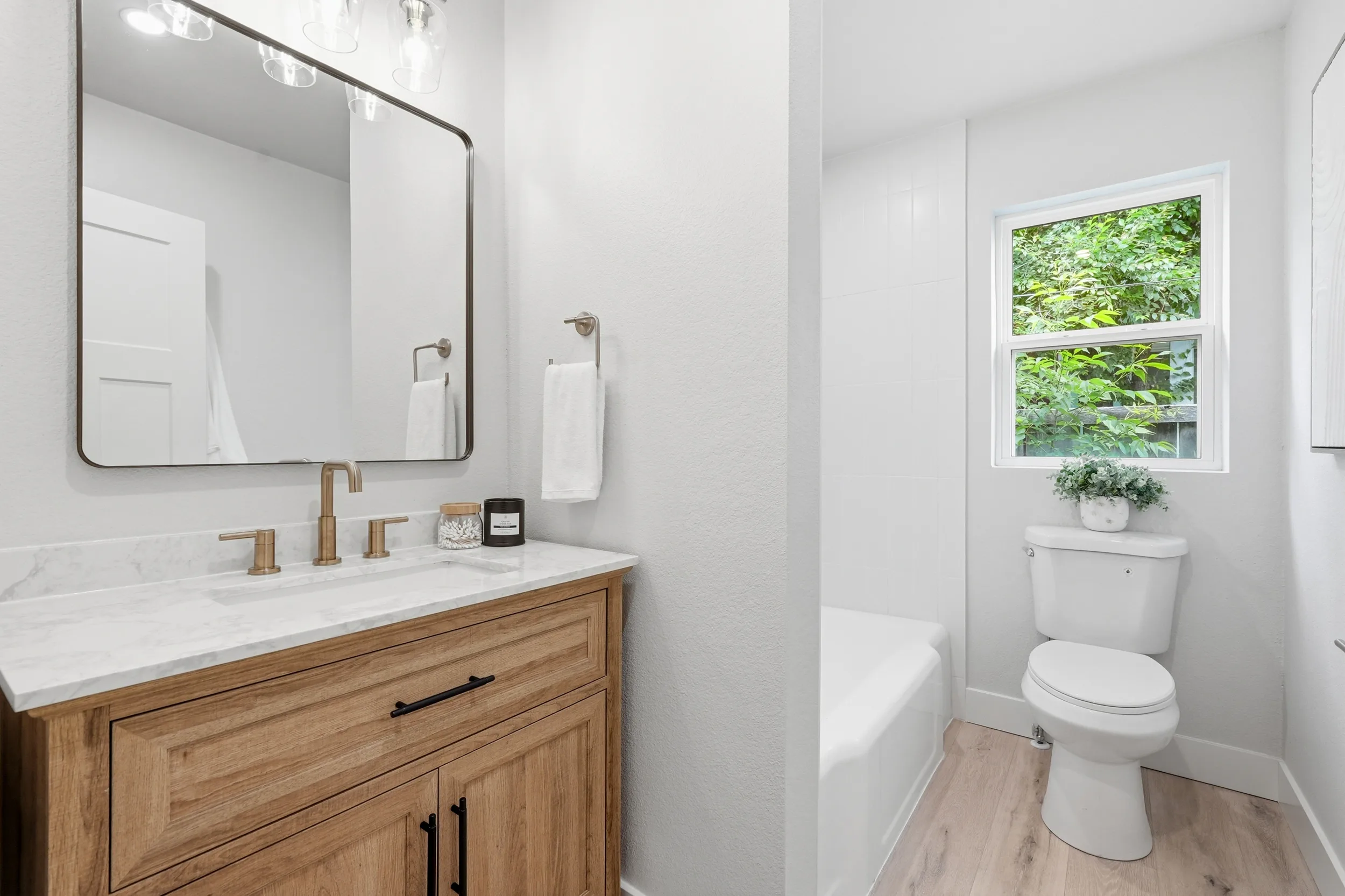Hall bathroom with a tub and wood vanity